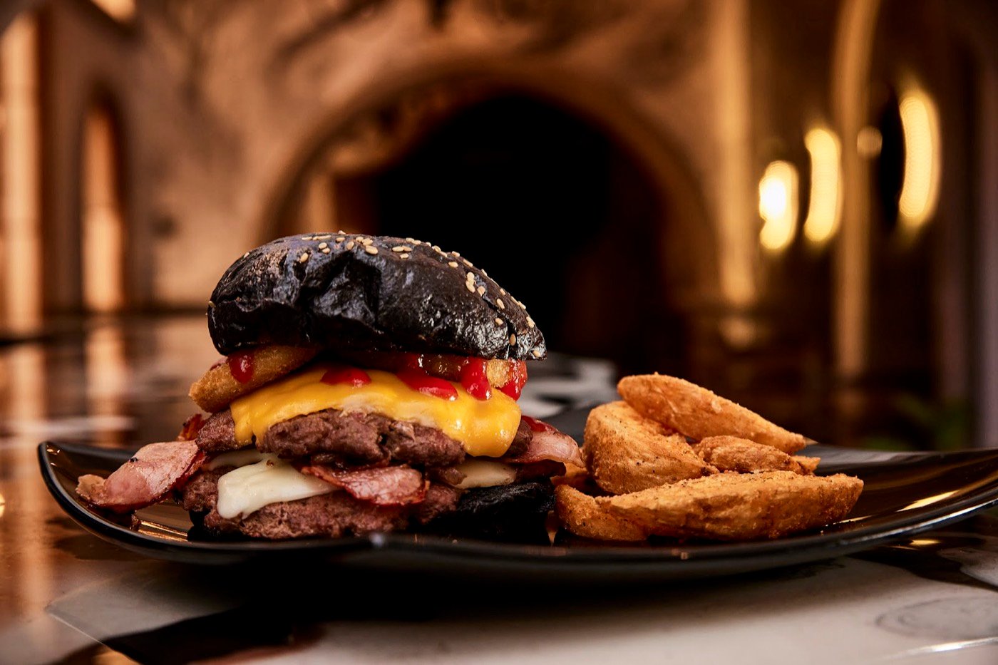 Hamburguesa con papas bajo las bóvedas